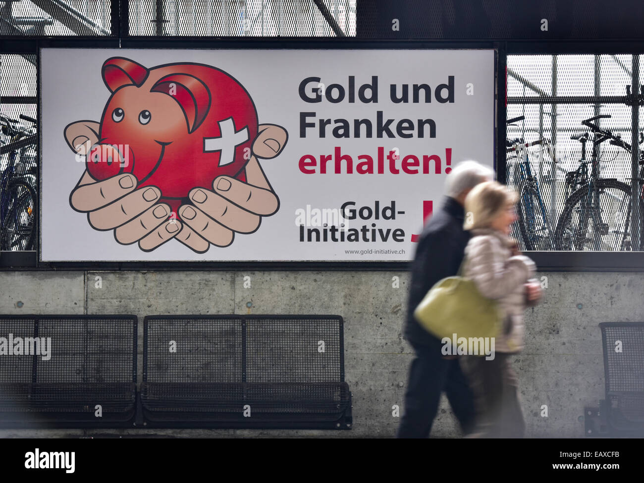 Zürich, Schweiz. 21. November 2014. Menschen im Zürcher Hauptbahnhof sind auf der Durchreise durch Referendum Plakaten das Schweizer Gold-Initiative Referendum am 30. November 2014 stattfinden wird. Mit einer Woche zu gehen wird die Kampagne für das Referendum der Schweizer Gold-Initiative in voller Stärke in der ganzen Schweiz. Das umstrittene Referendum strebt zu zwingen, die Schweizerische Nationalbank, mindestens 20 % aller Vermögenswerte in physisches Gold zu halten. Bildnachweis: Erik Tham/Alamy Live-Nachrichten Stockfoto