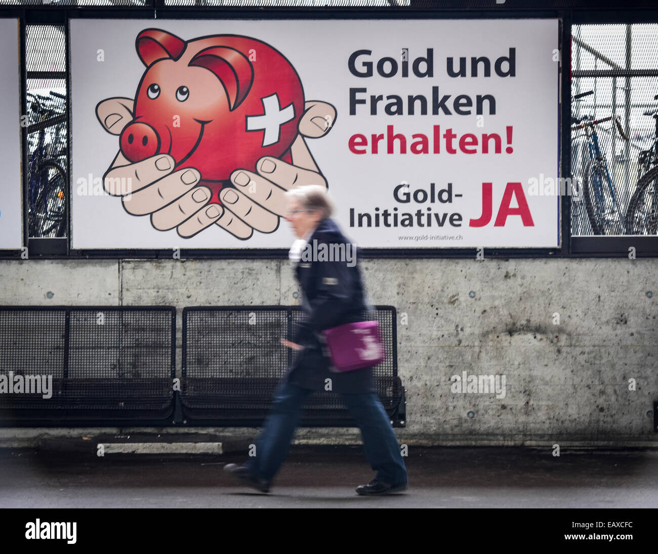 Zürich, Schweiz. 21. November 2014. Menschen im Zürcher Hauptbahnhof sind auf der Durchreise durch Referendum Plakaten das Schweizer Gold-Initiative Referendum am 30. November 2014 stattfinden wird. Mit einer Woche zu gehen wird die Kampagne für das Referendum der Schweizer Gold-Initiative in voller Stärke in der ganzen Schweiz. Das umstrittene Referendum strebt zu zwingen, die Schweizerische Nationalbank, mindestens 20 % aller Vermögenswerte in physisches Gold zu halten. Bildnachweis: Erik Tham/Alamy Live-Nachrichten Stockfoto