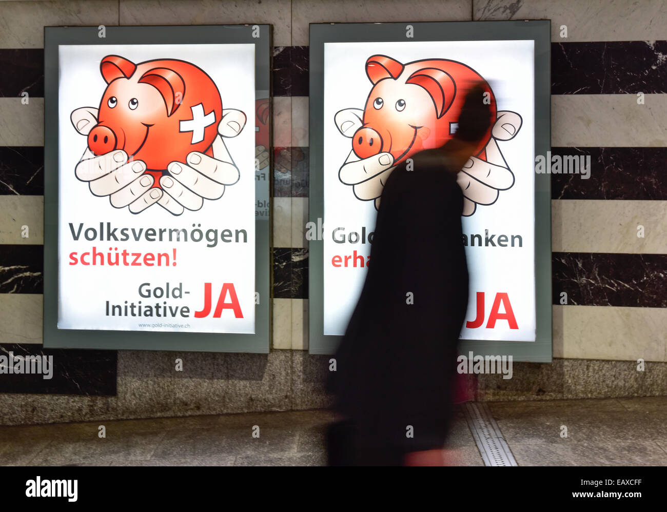 Zürich, Schweiz. 21. November 2014. Menschen im Zürcher Hauptbahnhof sind auf der Durchreise durch Referendum Plakaten das Schweizer Gold-Initiative Referendum am 30. November 2014 stattfinden wird. Mit einer Woche zu gehen wird die Kampagne für das Referendum der Schweizer Gold-Initiative in voller Stärke in der ganzen Schweiz. Das umstrittene Referendum strebt zu zwingen, die Schweizerische Nationalbank, mindestens 20 % aller Vermögenswerte in physisches Gold zu halten. Bildnachweis: Erik Tham/Alamy Live-Nachrichten Stockfoto