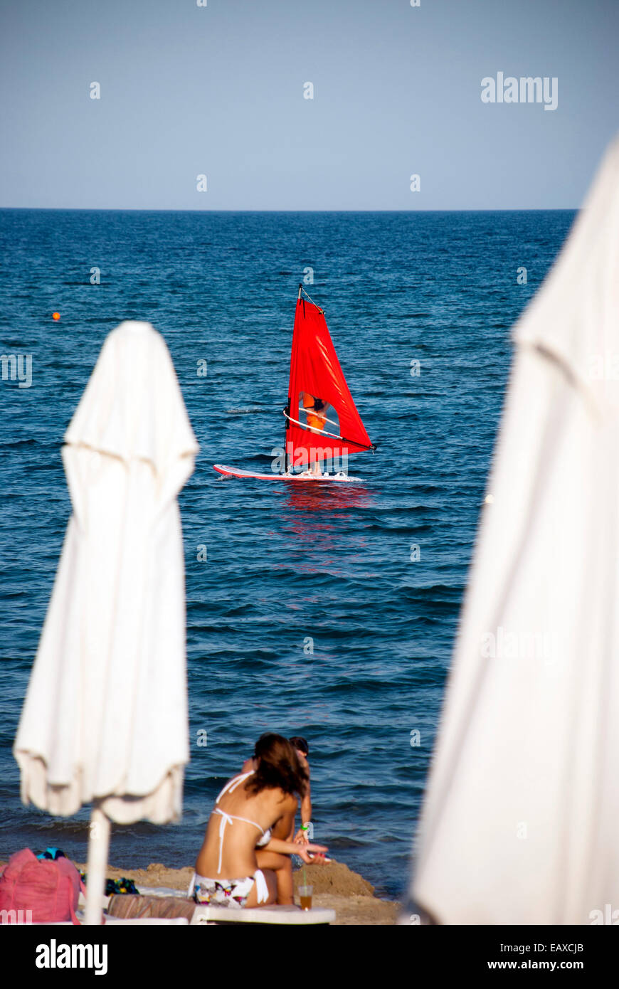 Sonnenstrand, Bulgarien - 15. Juli 2011: Eine Windsurfer ist eine Fahrt mit seinem Surf an Bulgariens Schwarzmeerküste haben, während eine Frau Wat ist Stockfoto