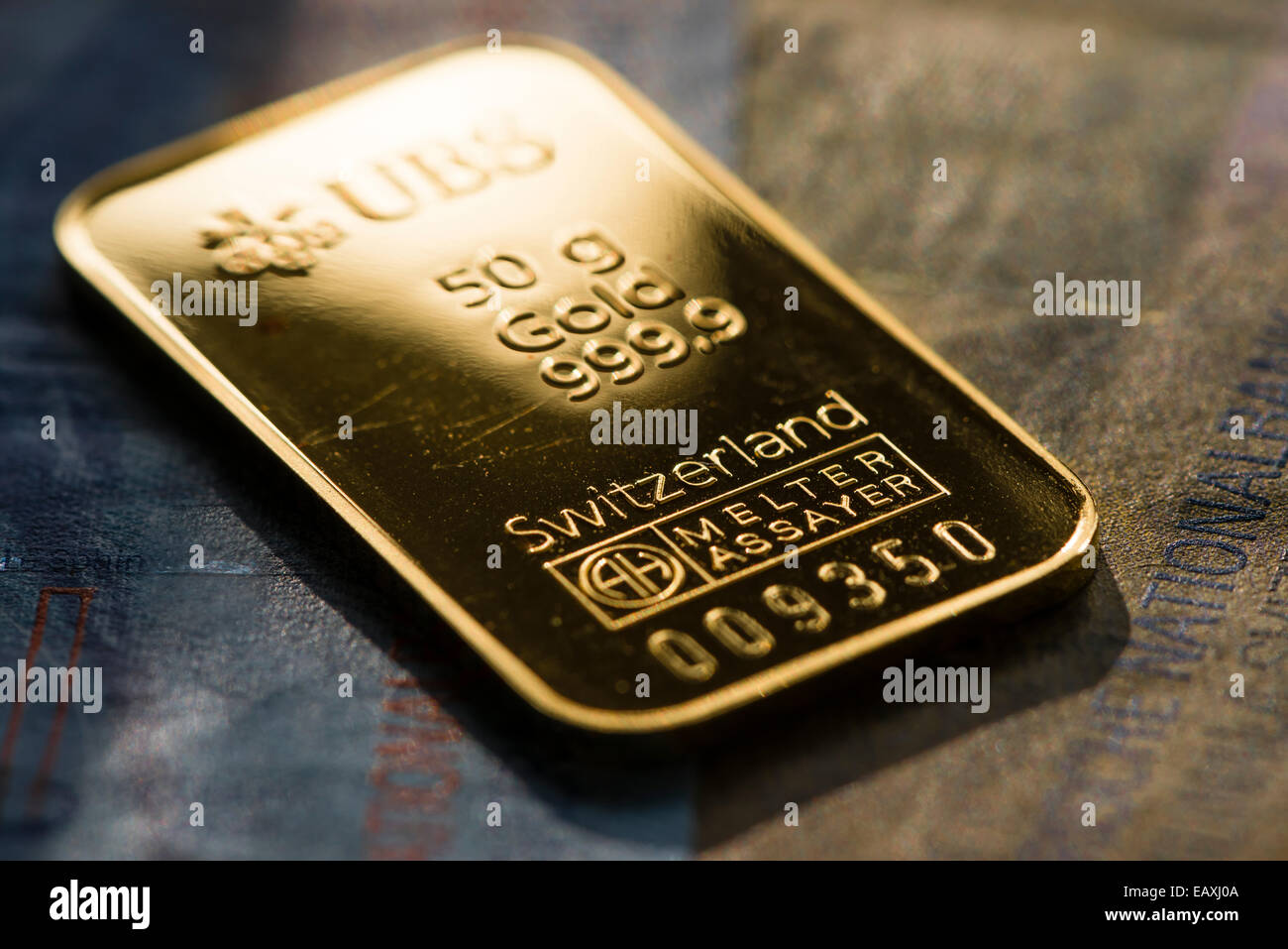 Ein 50g gold-Barren aus Schweizer Minze, platziert auf Schweizerfranken Noten. Stockfoto
