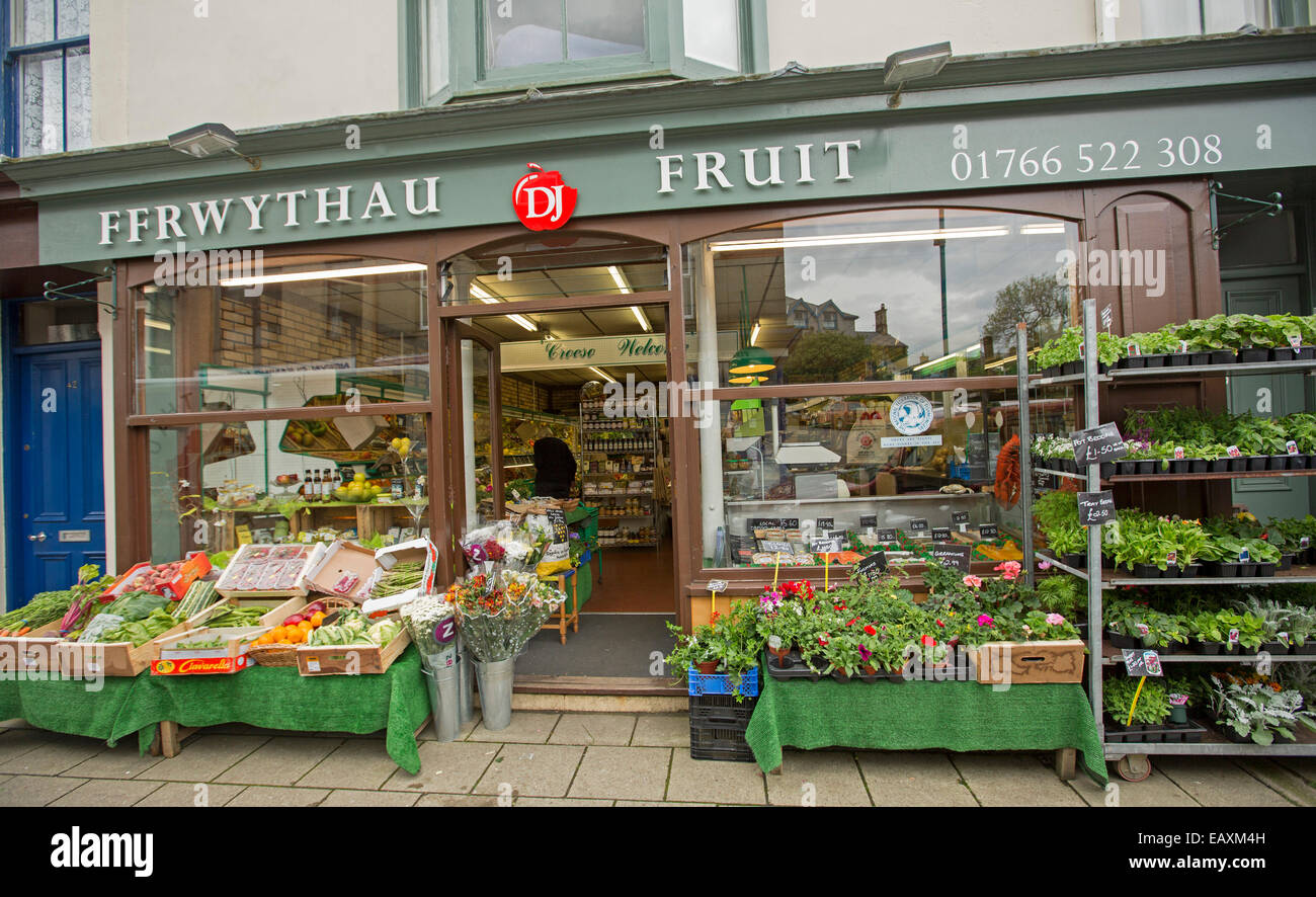 Obstladen in Criccieth, Wales mit Zeichen in beiden Englisch & Welsh, Kisten mit Obst für den Verkauf auf Fußweg Stall & Kunden innerhalb Stockfoto