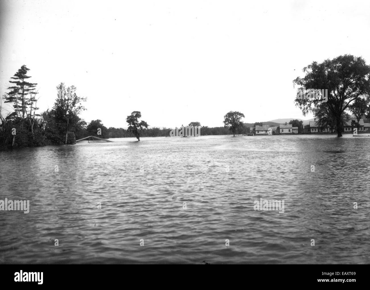Ein Foto von Bion Whitehouse zeigt die verheerende Flut in Keene, New Hampshire, und stellt die hohen Wasserstände dar, die erhebliche Schäden in der Gegend verursachten, wobei der Einfluss der Naturkatastrophe auf die Stadt und ihre Umgebung betont wird. Stockfoto