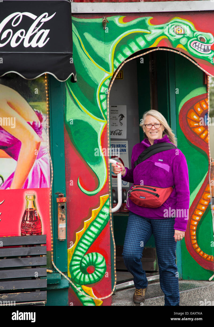 Bunt gekleidete Frau verlassen Drenkin Grill auf Laugavegur Straße in der Innenstadt von Reykjavik, Island Stockfoto