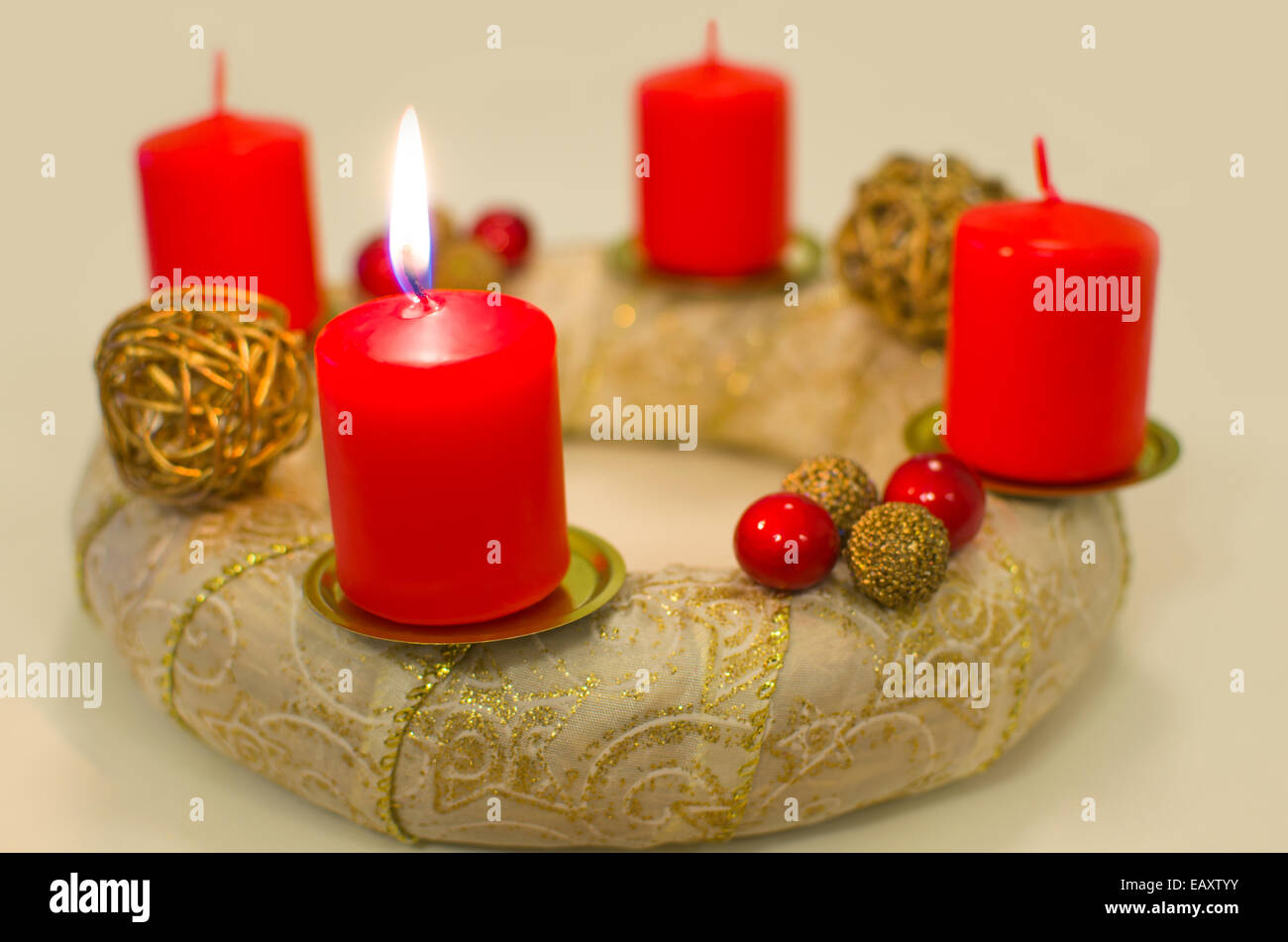Beleuchtete goldene Adventskranz mit dicken roten Kerzen Stockfoto