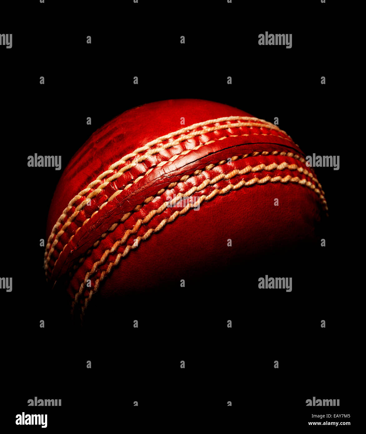 Lederball Cricket rot auf schwarz Stockfoto