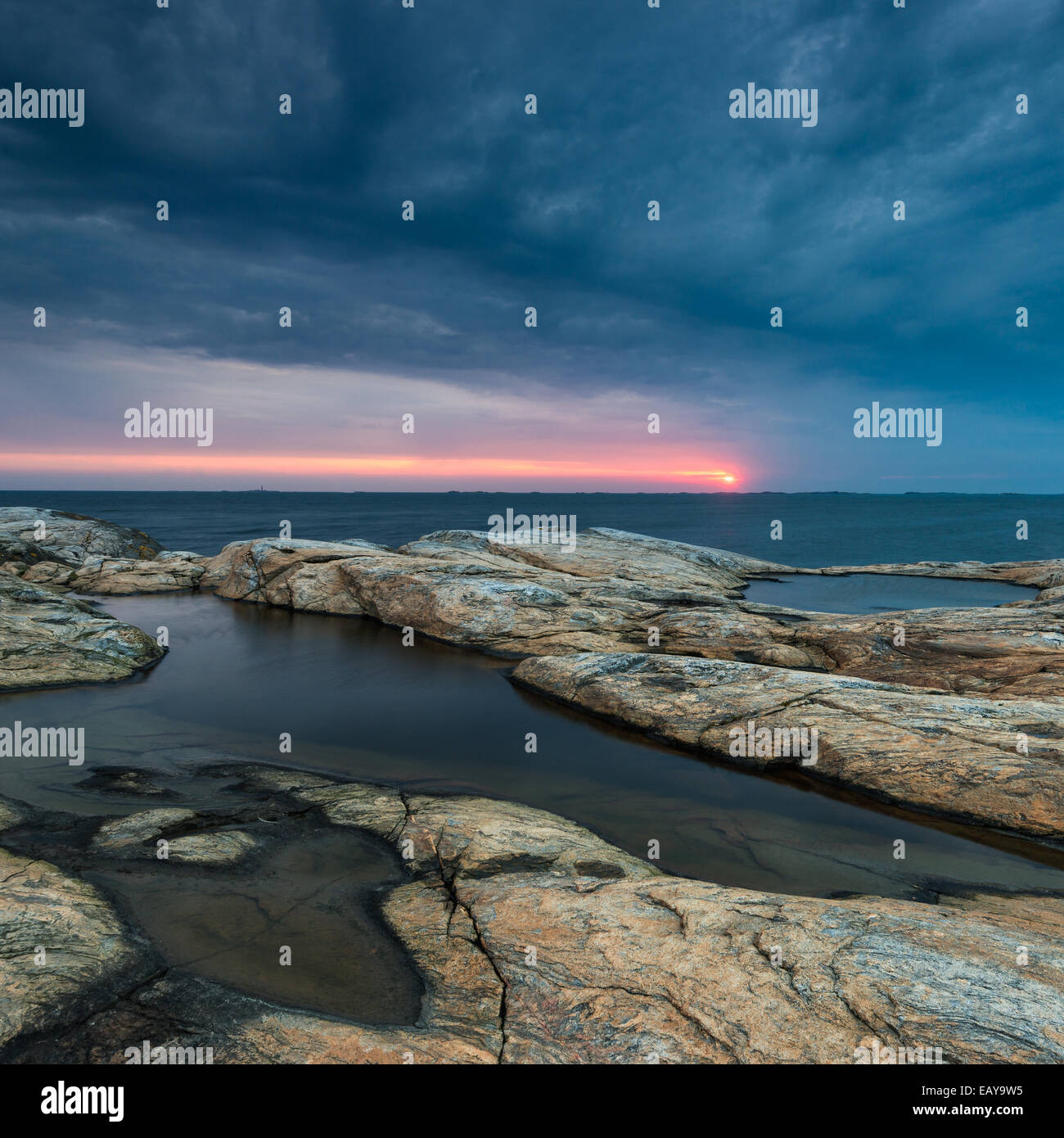 Felsige Küste mit dramatischer Himmel bei Sonnenuntergang Stockfoto