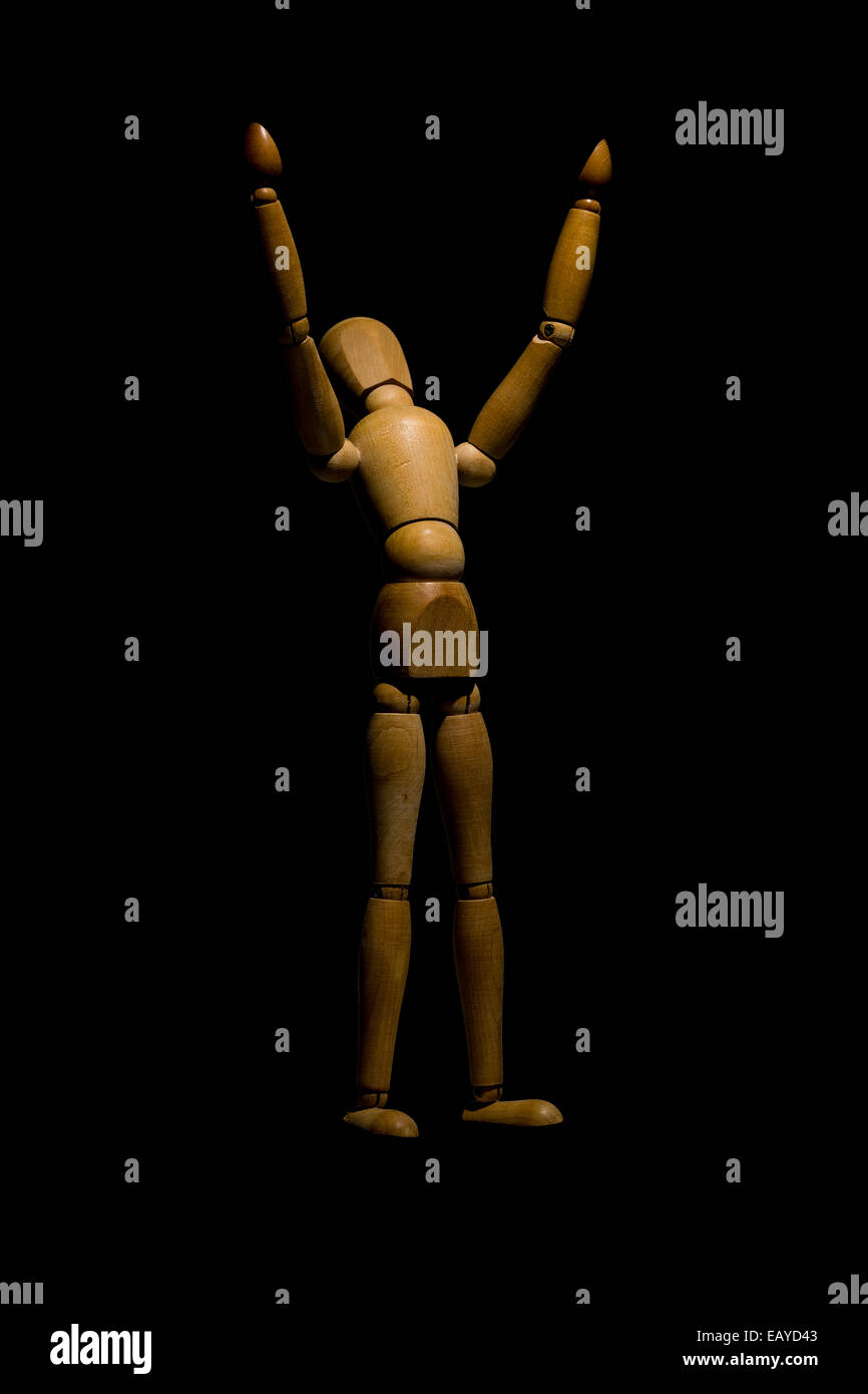 Hölzerne Schaufensterpuppe Hände ans Licht, die isoliert auf schwarz. Stockfoto