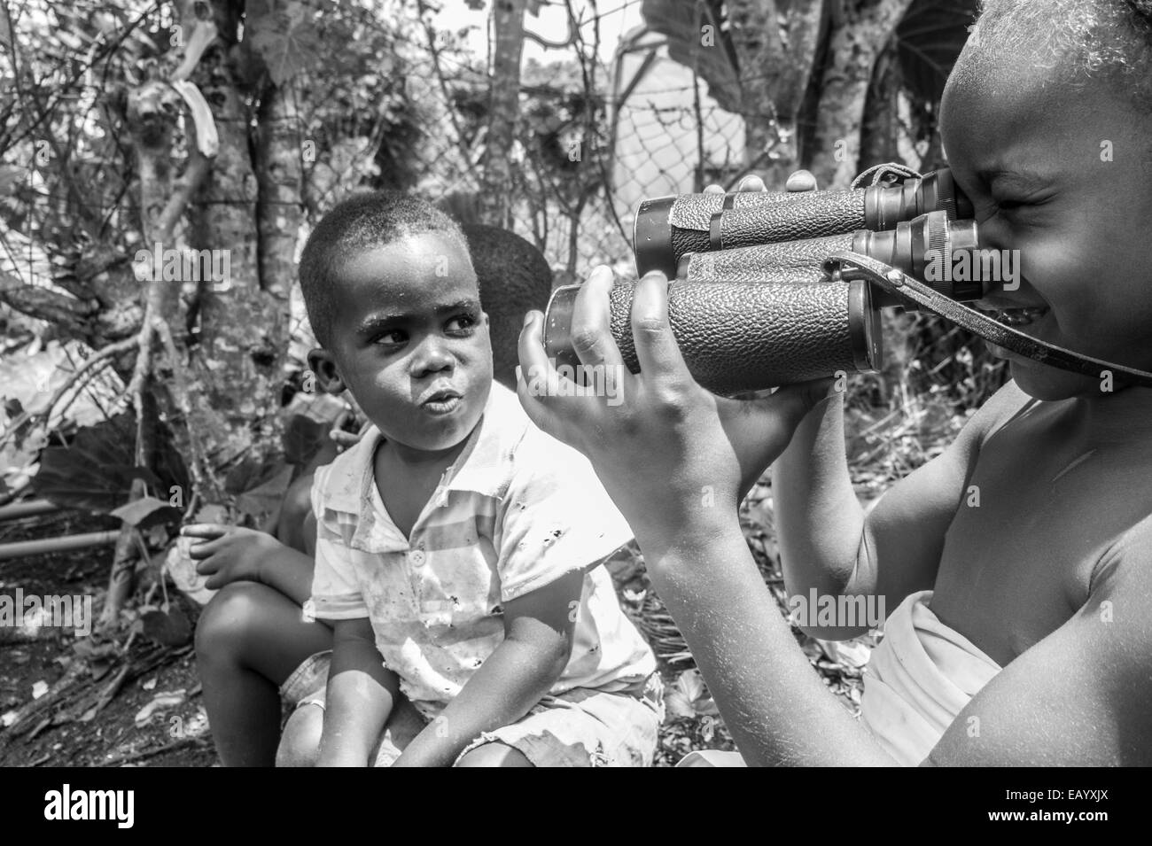 Kinder spielen mit einem Fernglas in der Ortschaft San Joaquim (Príncipe, Golf von Guinea) Stockfoto