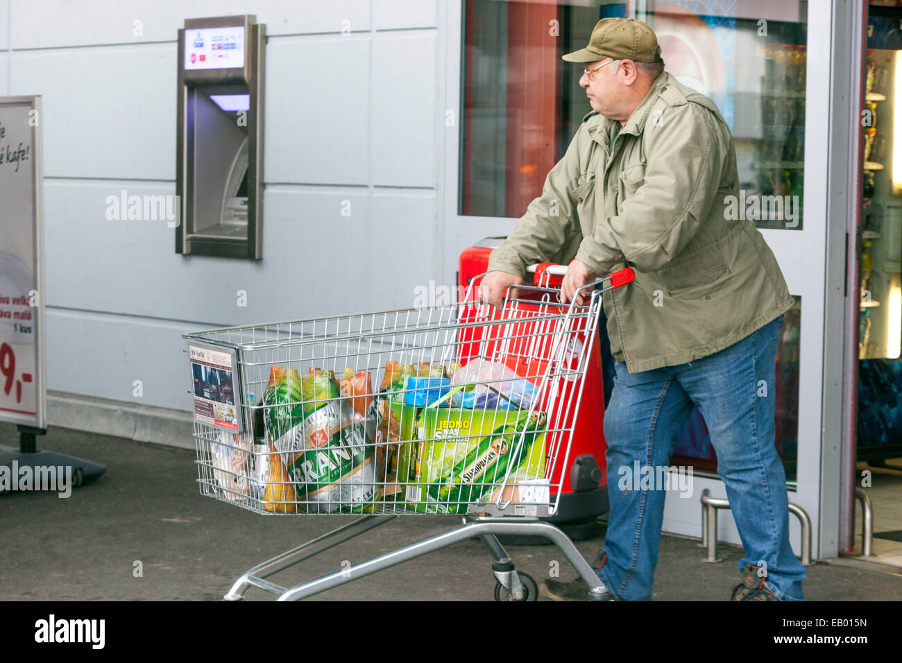 Supermarkt Trolley Shopper Senior Erwachsene Person Schieben Trolley außerhalb Mann Warenkorb Shopper Kunden Warenkorb Schieben Cart Retiree Stockfoto