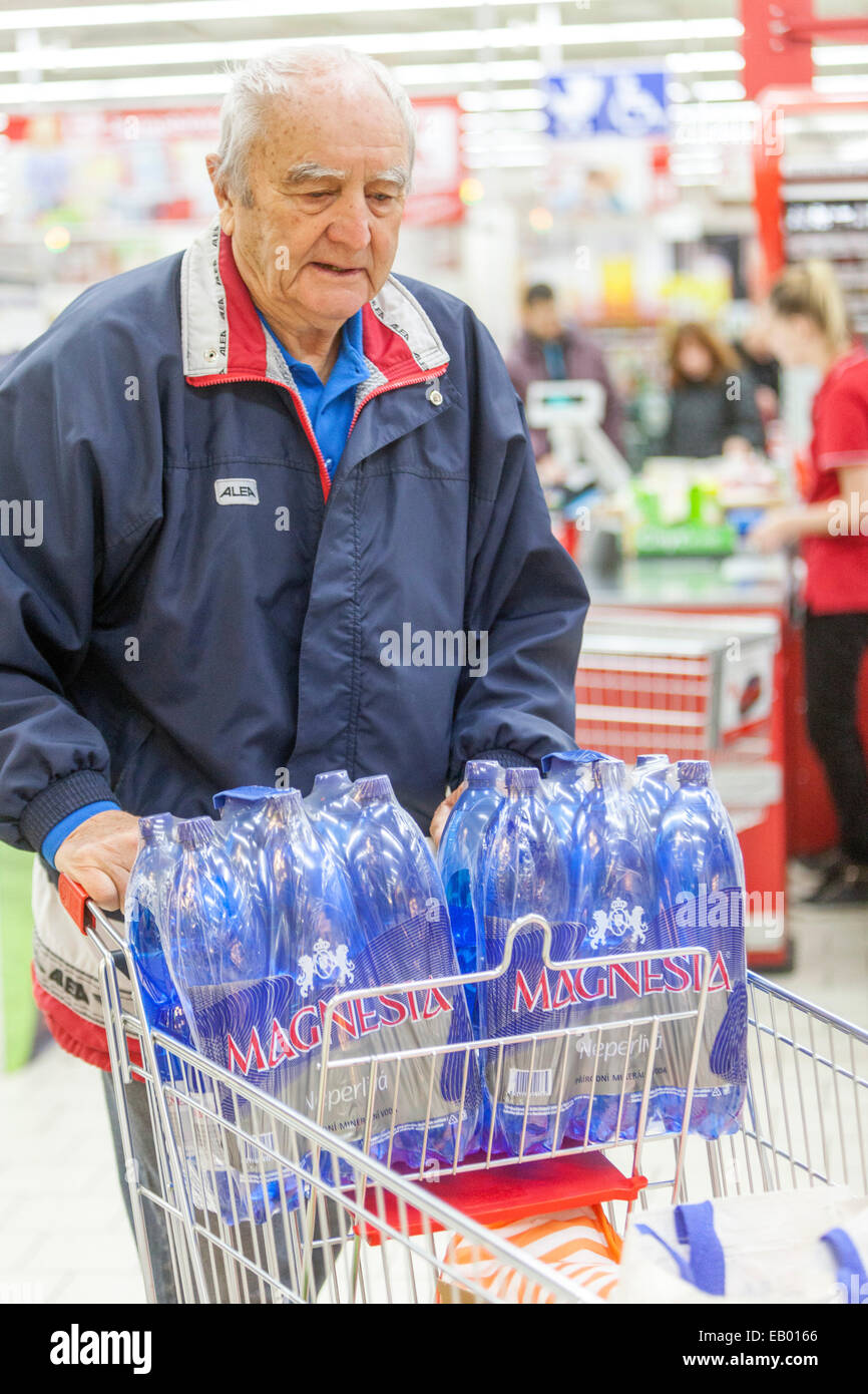 Erwachsener Seniorenmann schiebt Trolley-Shopping im Supermarkt, Mineralwasser Prag, Tschechische Republik Europa Stockfoto