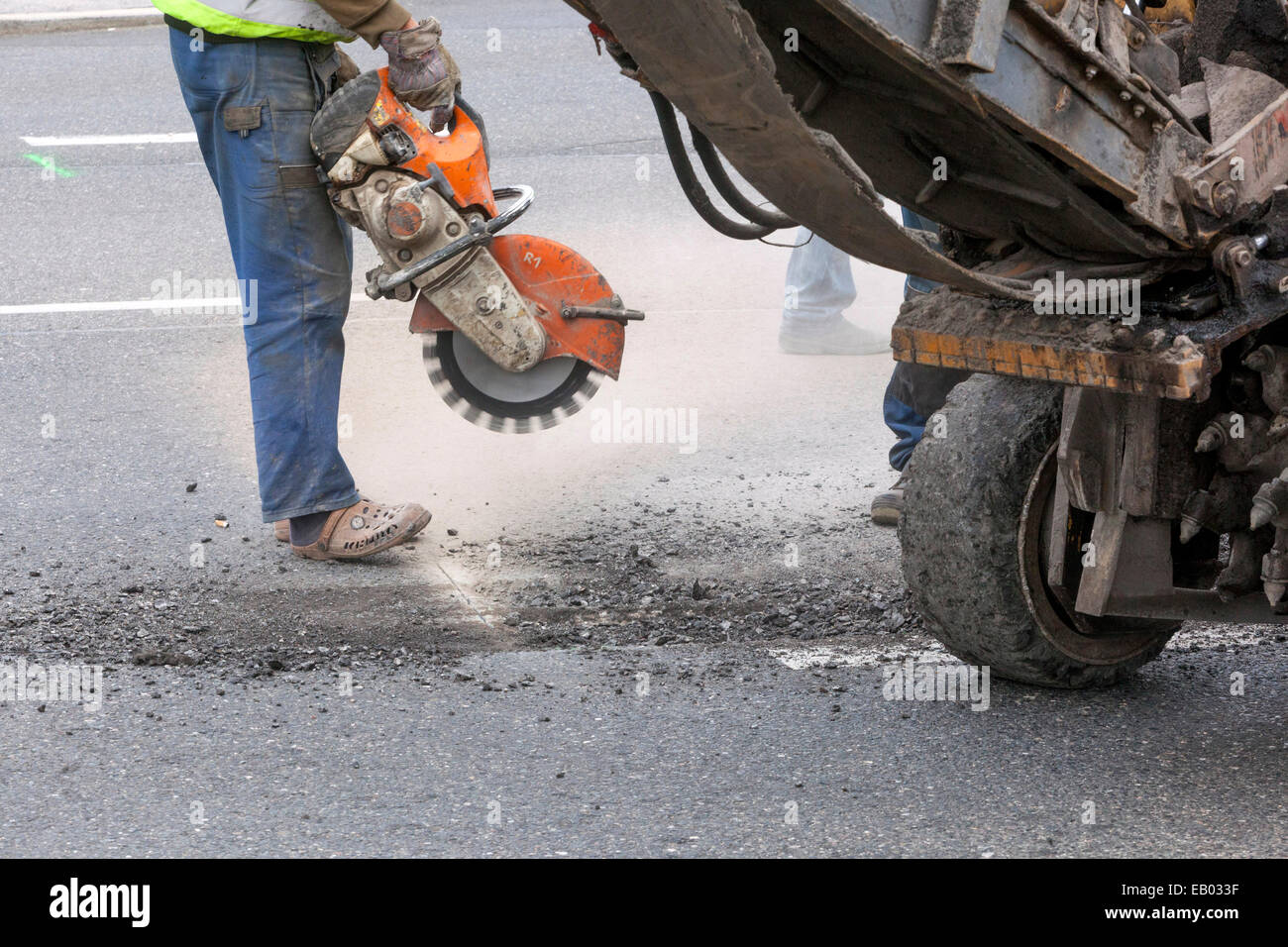 Ein Mann arbeitet Asphalt mit einem Diamond cutter Ausschneiden, keine schützende Arbeit Gang, Tschechische Republik Stockfoto