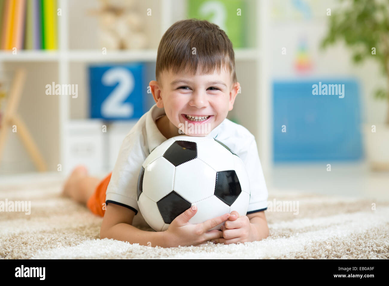 Kind Junge mit dem Fußball zu Hause Stockfoto