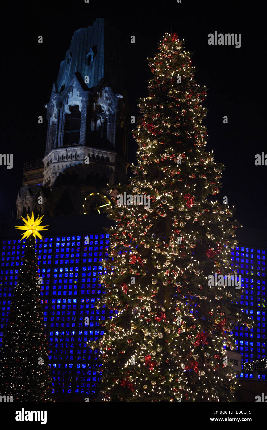 Berlin, Deutschland. 22. November 2014. Ein geschmückter Weihnachtsbaum beleuchtet auf dem Weihnachtsmarkt an der Kaiser-Wilhelm-Gedächtniskirche in Berlin, Deutschland, 22. November 2014. Die neuen Gedächtniskirche leuchtet blau hinter die Weihnachtsbäume. Viele Weihnachtsmärkte eröffnen am Montag in der Hauptstadt. Foto: Rainer Jensen/Dpa/Alamy Live-Nachrichten Stockfoto
