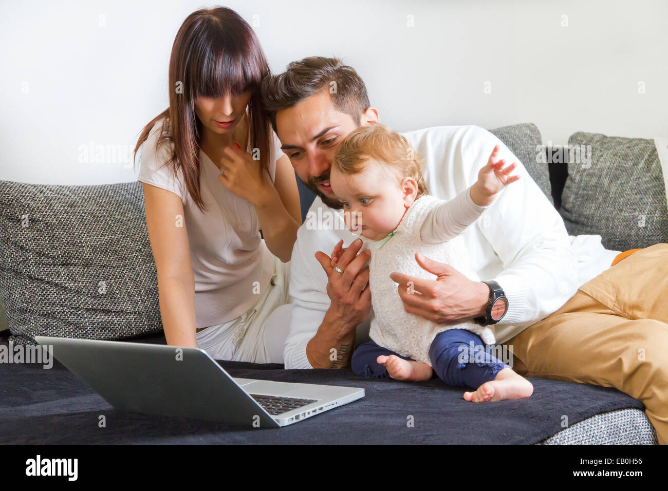 Junge Familie auf einem laptop Stockfoto