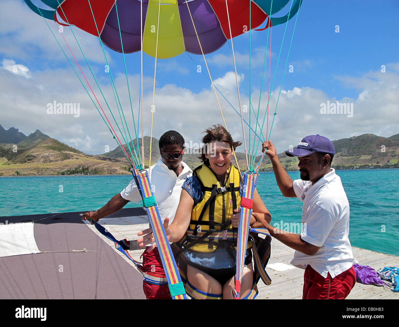 Eine Frau mittleren Alters Alter 50er Jahre Vorbereitung, Paragliding (parasailing) in Mauritius zu gehen Stockfoto