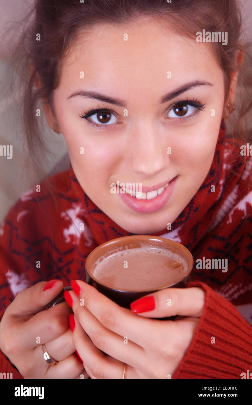 Mädchen in einem roten Pullover Kakao trinken Stockfoto