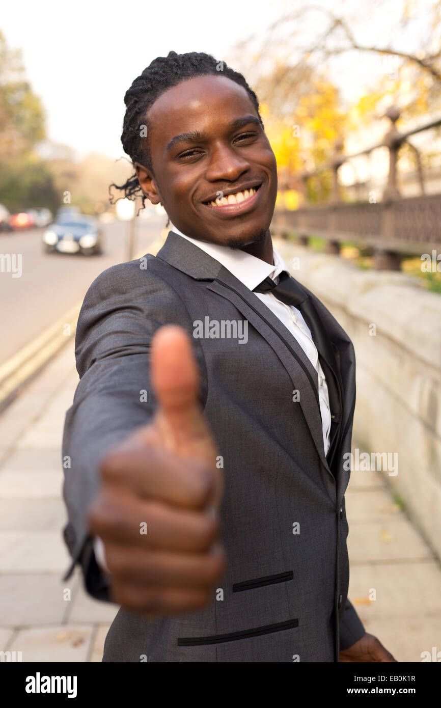 junger Geschäftsmann zeigt ein Daumen hoch Geste. Stockfoto