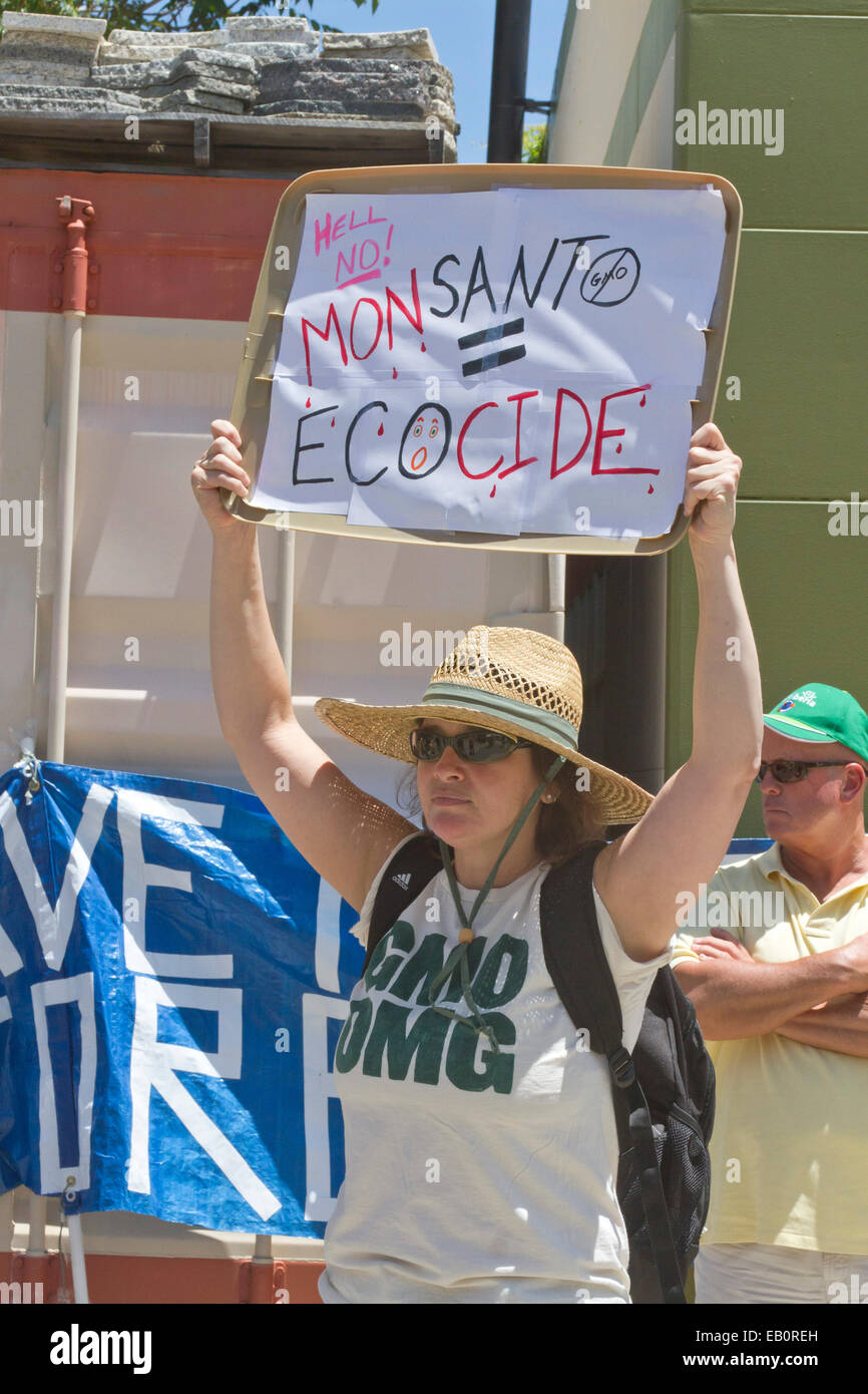 Junge Frau hält einen Schild Spruch "MONSANTO = ÖKOZID" bei einer Protestkundgebung für GVO-Lebensmittel Stockfoto