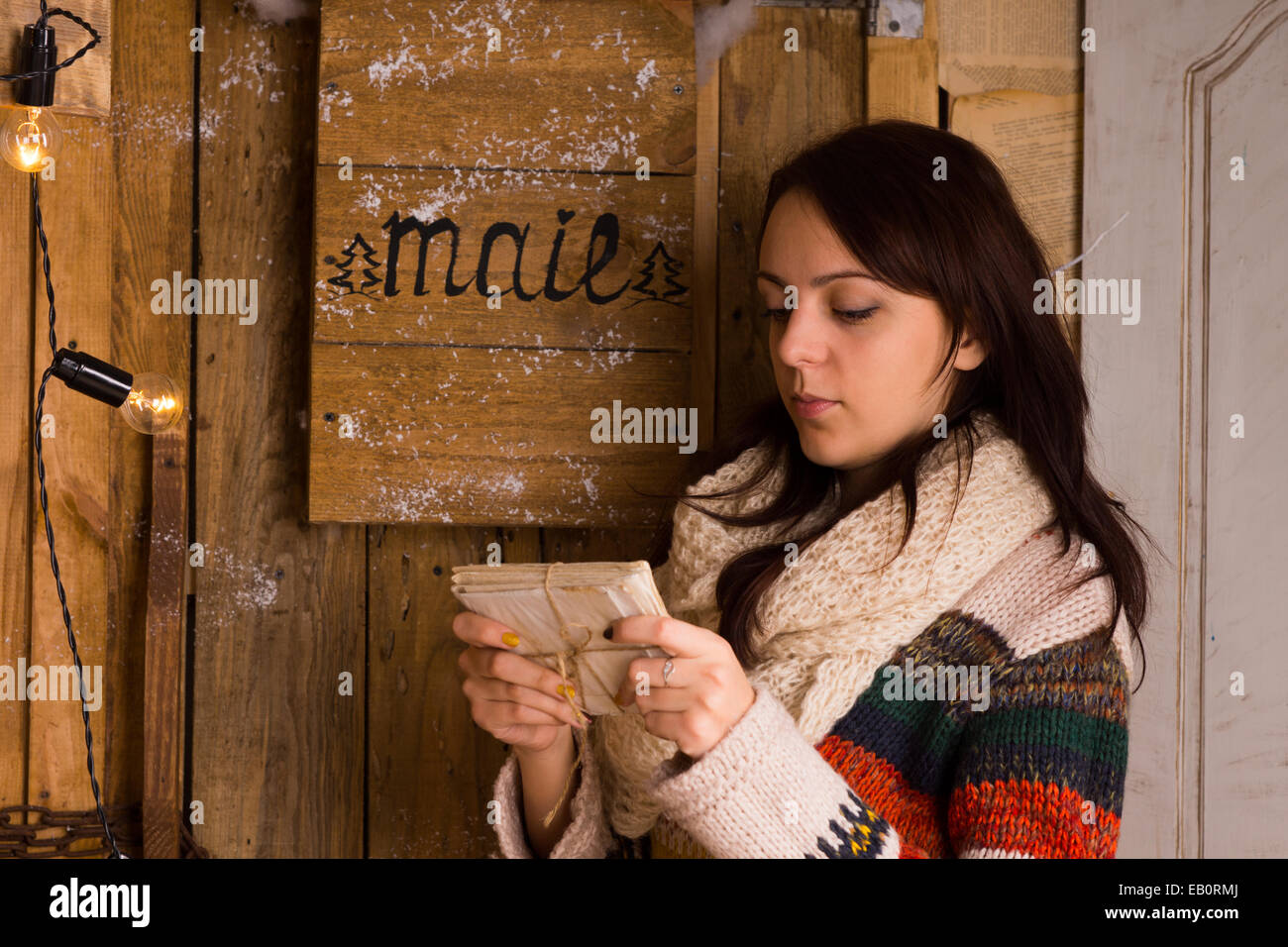 Frau, die Prüfung ein Bündel von Briefen, verbunden mit einer Schnur aus der Mail-Box mit einem schweren kontemplativen Ausdruck, Seitenansicht Stockfoto
