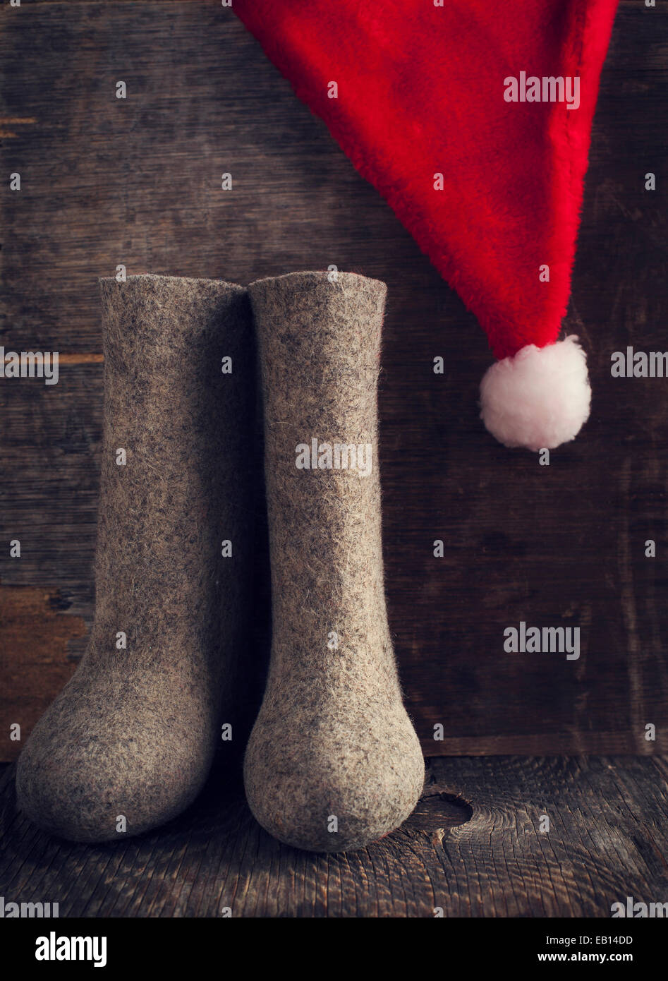 Weihnachten Weihnachtsmann Mütze und Filzstiefel auf hölzernen Hintergrund. Durchtrainierten Bild. Stockfoto