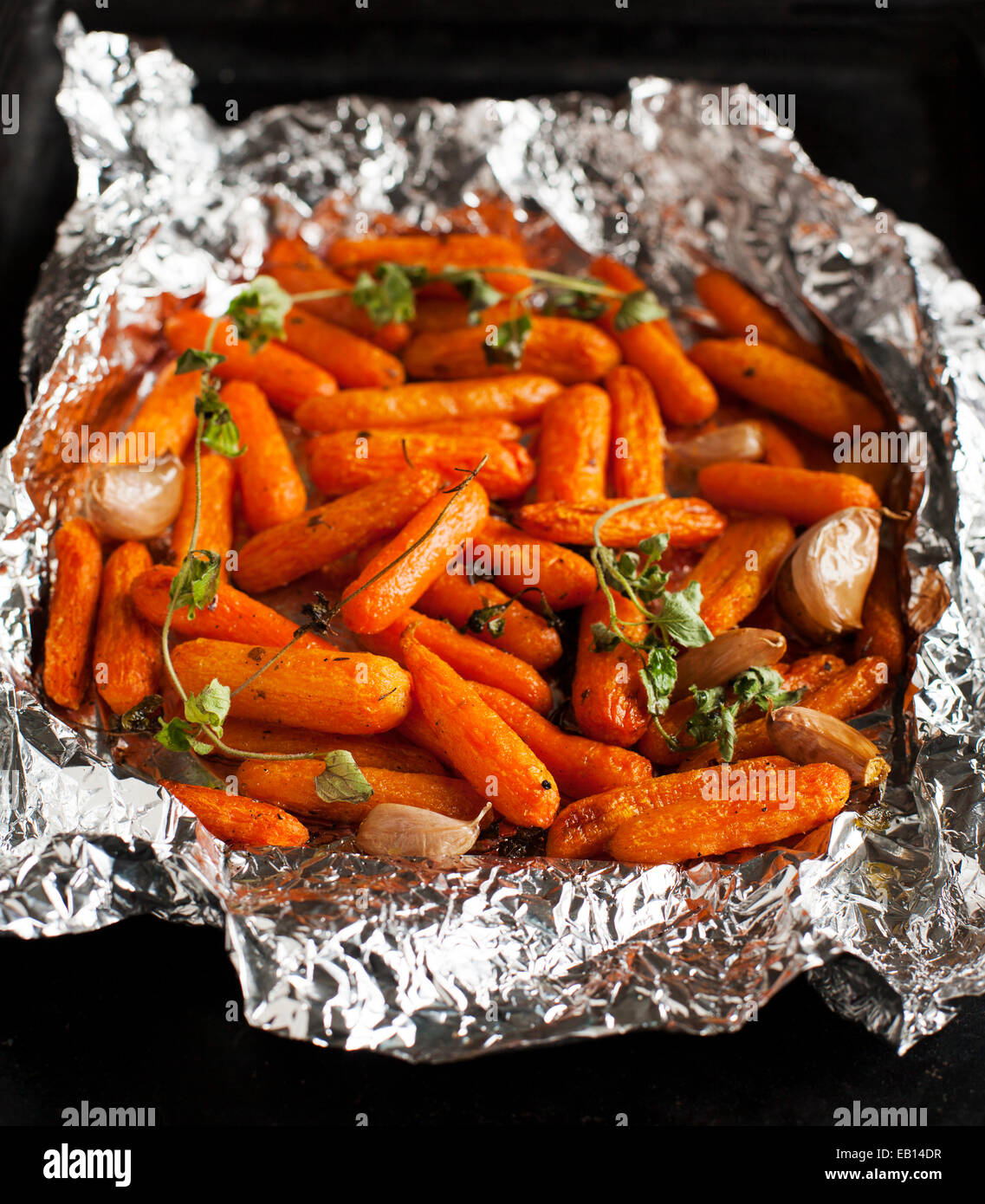 Gebackene Baby-Karotten mit Knoblauch und oregano Stockfoto