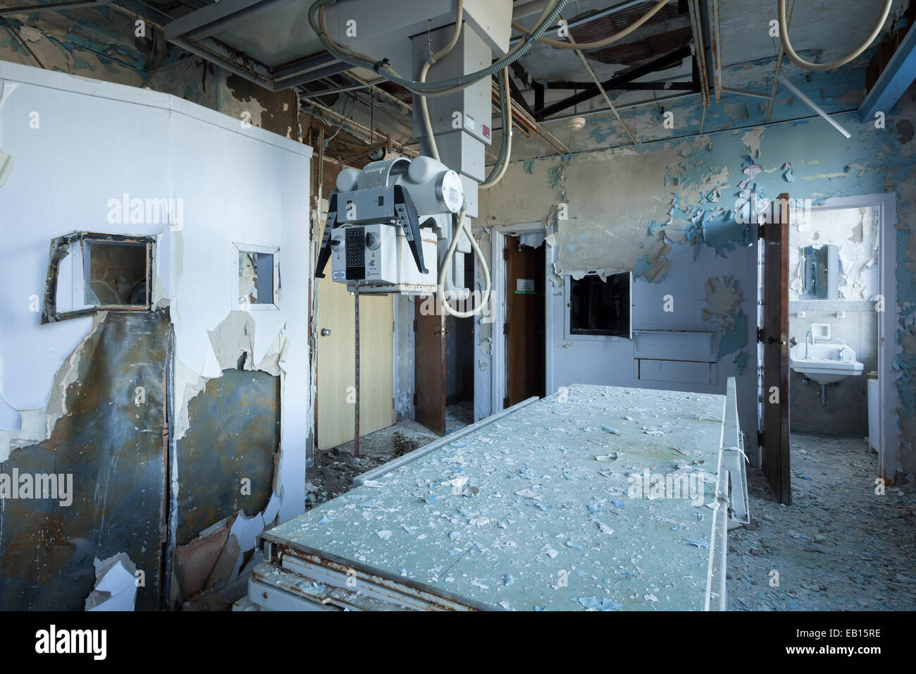 Ein Röntgengenerator und einer exponierten Blei-Wand in einem verlassenen Krankenhaus Radiologie Zimmer Tisch. Ontario, Kanada. Stockfoto