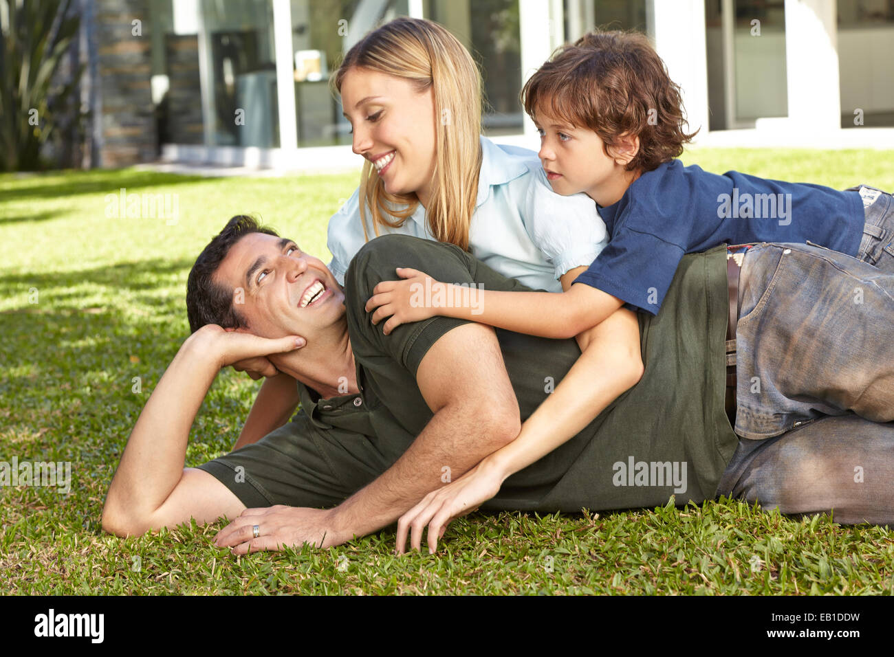 Glückliche Familie mit Sohn verlegen im Garten vor einem Haus Stockfoto