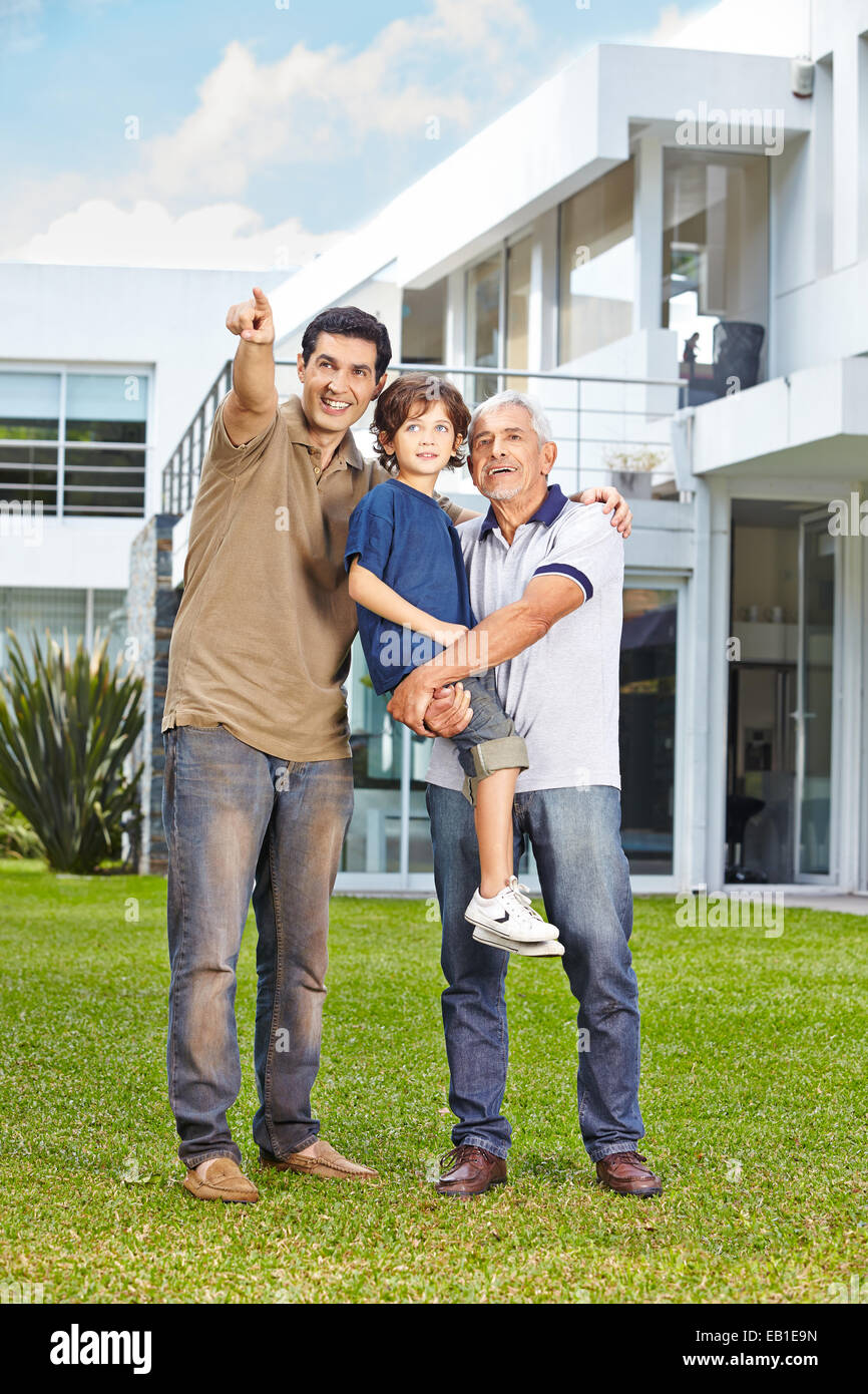 Männer einer Familie Blick in die Zukunft im Garten eines Hauses Stockfoto