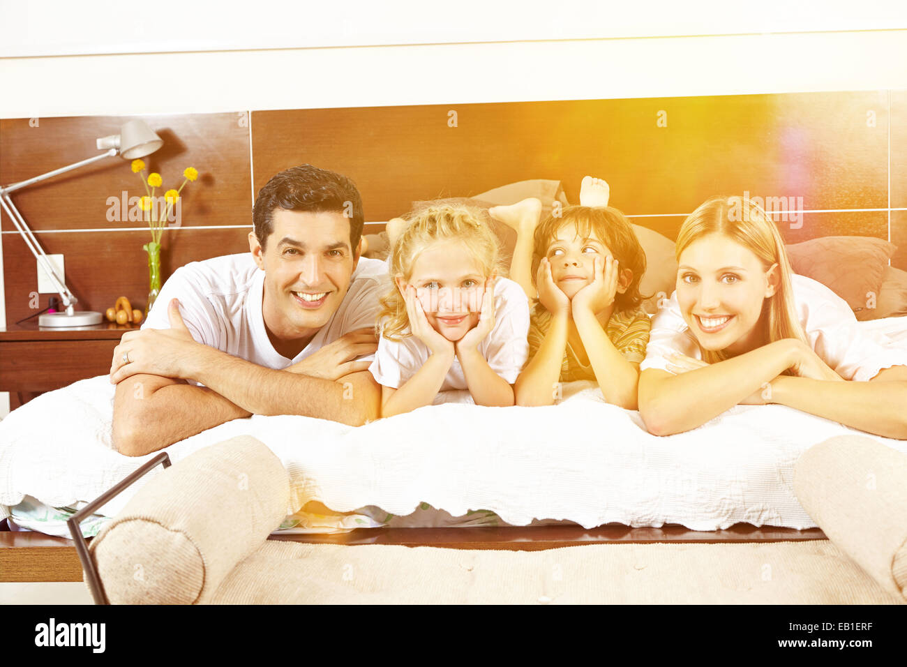 Glückliche Familie mit im Bett mit zwei Kindern im Sommer Stockfoto