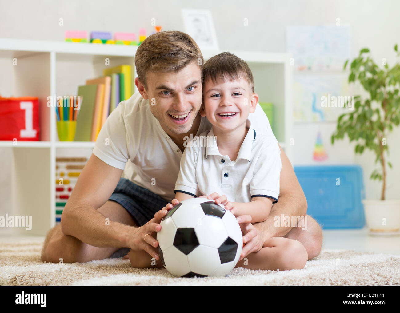 Kind Junge mit Papa zu Hause Fußball spielen Stockfoto