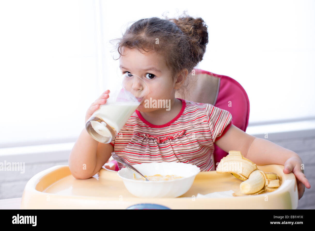 Hübsche Kinder trinken Milch aus Glas Stockfoto
