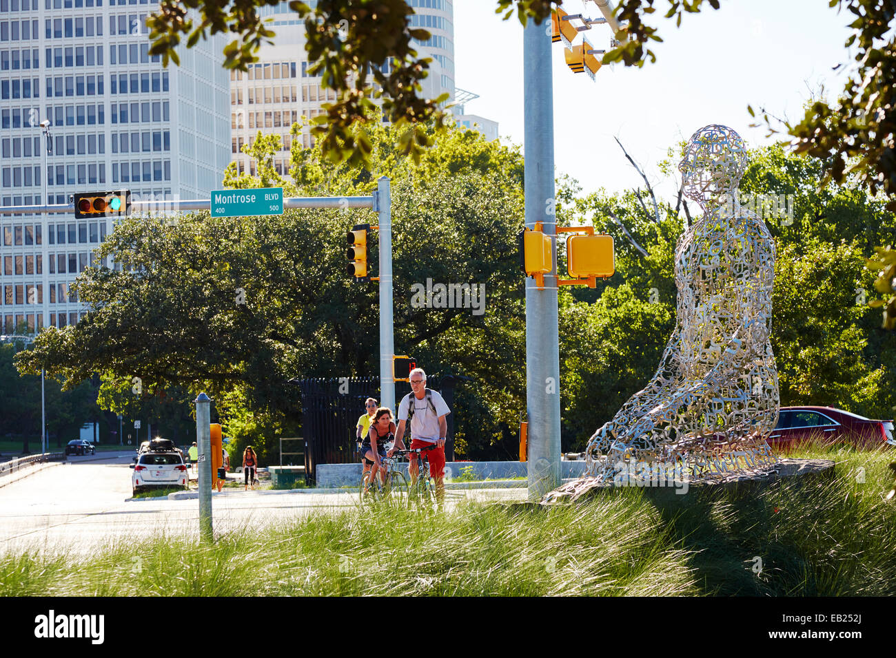 Familie Radfahren nach 1 von 7 Skulptur dieser Form "Toleranz" aka "Statuen in Allen Parkway und Montrose" in Houston, Texas USA Stockfoto