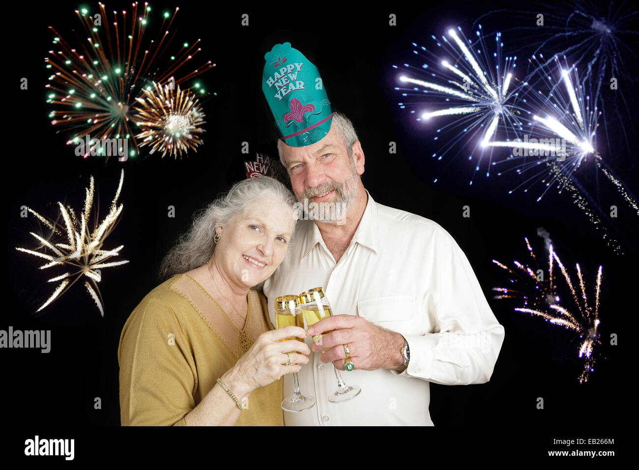 Schönes älteres Paar feiert ein frohes neues Jahr mit einem Champagner anstoßen, während Feuerwerk in den Hintergrund losgehen. Stockfoto