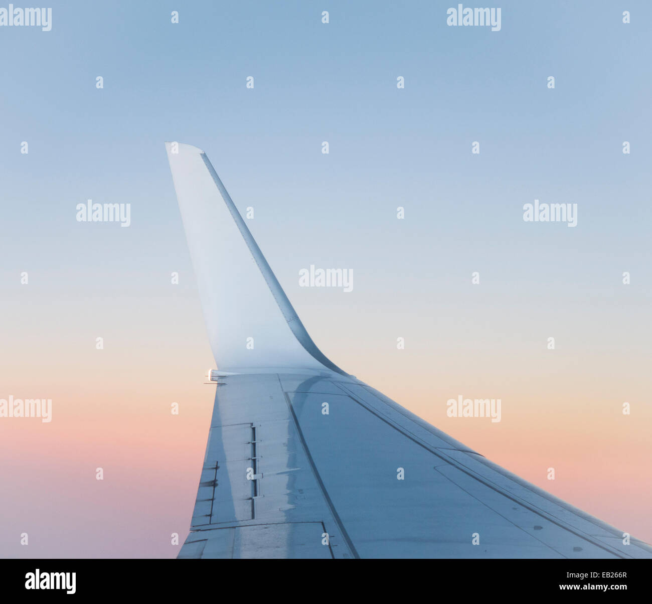 Blick auf den Flügel eines Passagierflugzeuges bei Sonnenuntergang Stockfoto