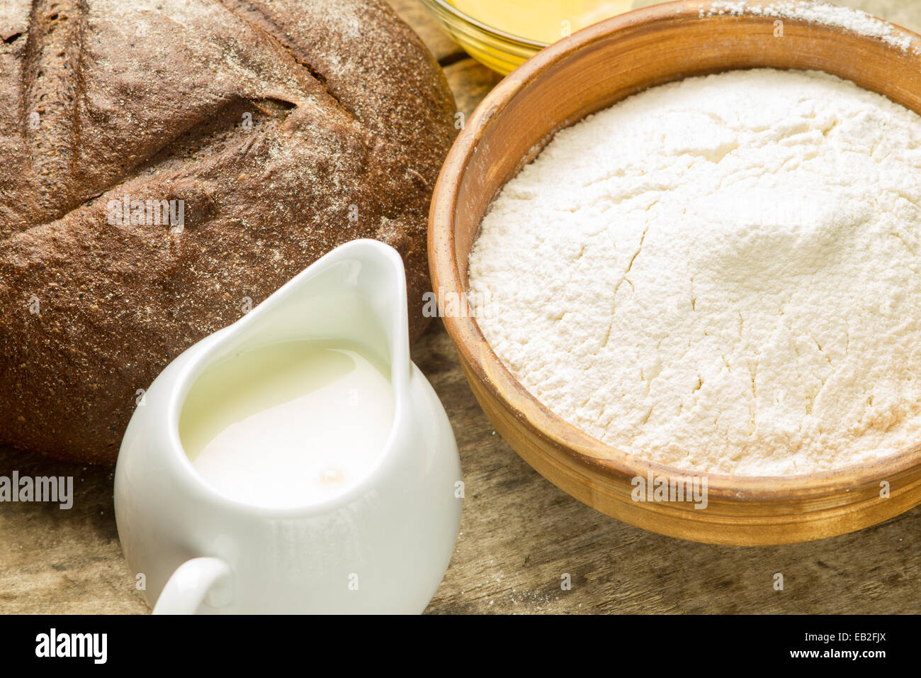 Bäckerei Zutaten Hintergrund. Roggenbrot mit Mehl und Milch auf Holztisch Stockfoto