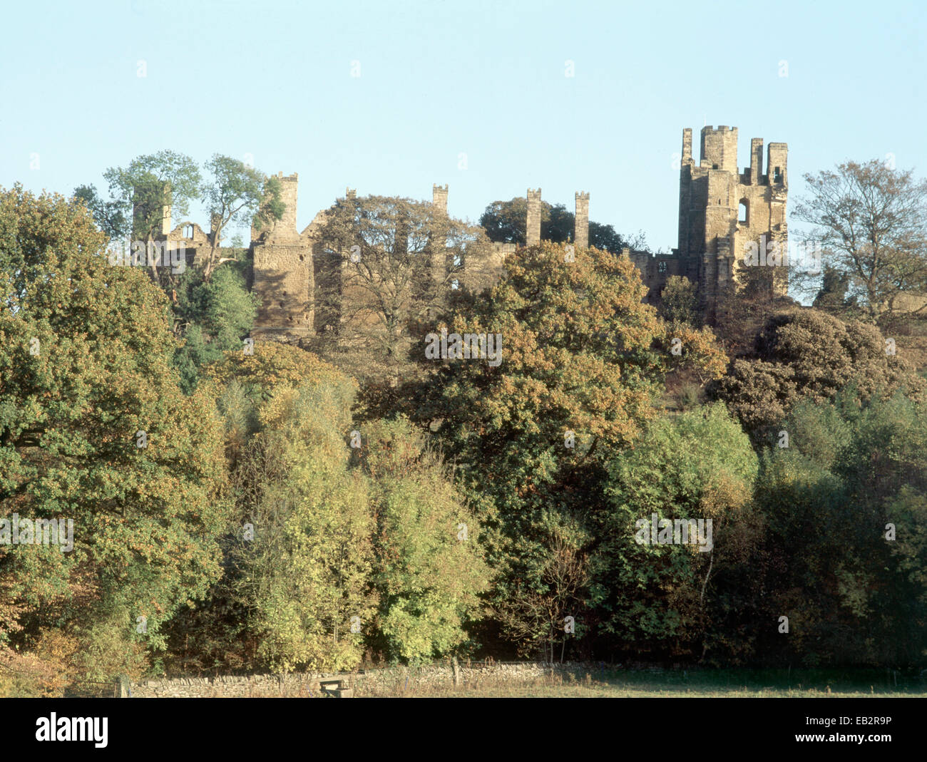 Zerstörte Herrenhaus auf Hügel, teilweise verdeckt von Bäumen, Wingfield Manor, Derbyshire, England, UK. Stockfoto