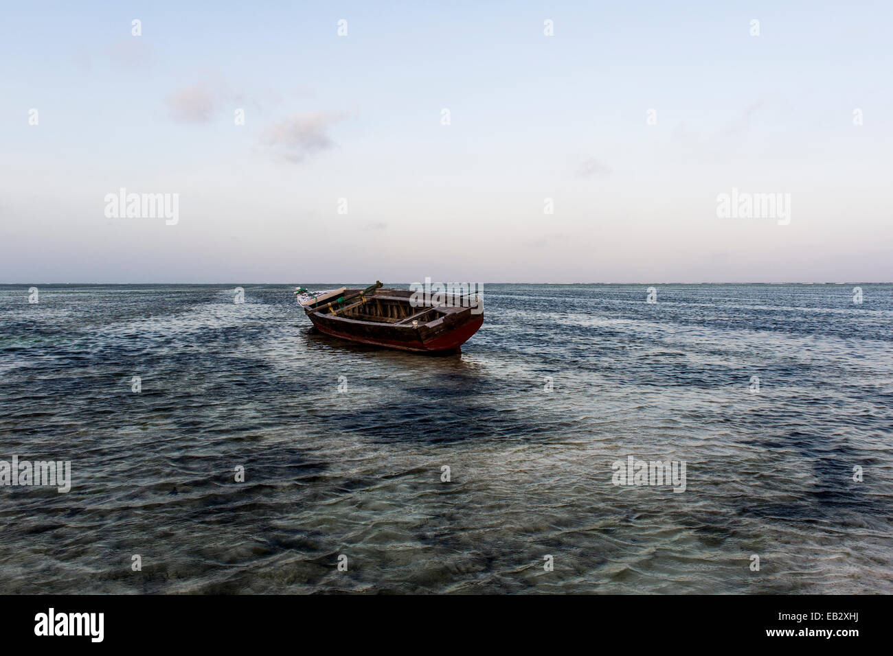 Ein Fischerboot vor Anker in den Untiefen einer tropischen Insel im Indischen Ozean. Stockfoto