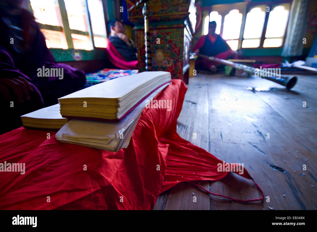 Haufen von Pergament in Sanskrit Text gespielt von buddhistischen Mönchen auf Langhorn Hörner Preisverleihung Tod in einem bhutanischen Haus abgedeckt. Stockfoto
