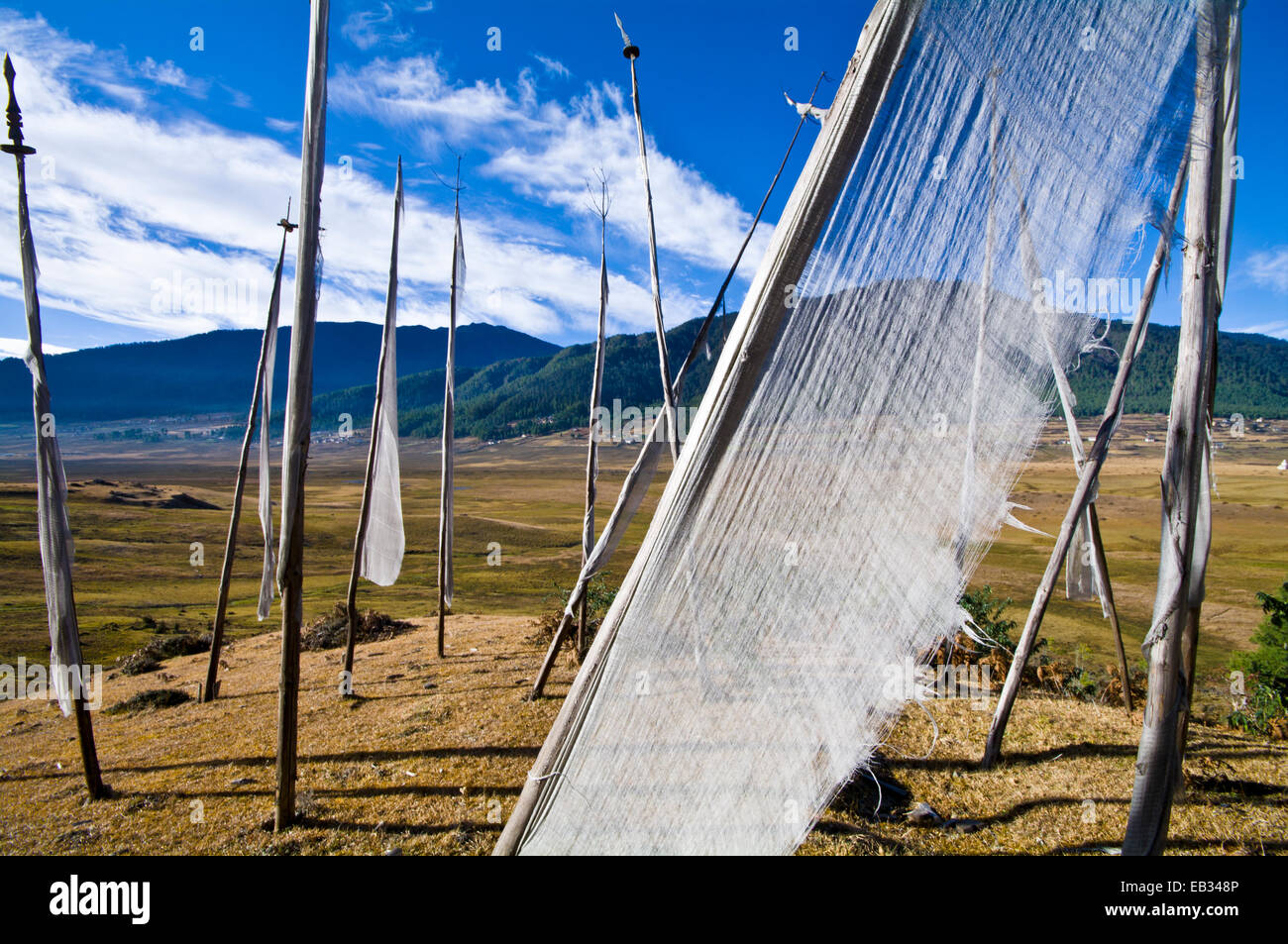 Das durchscheinende Tuch eine Gebetsfahnen flattern im Wind über ein Himalaya-Feuchtgebiet. Stockfoto