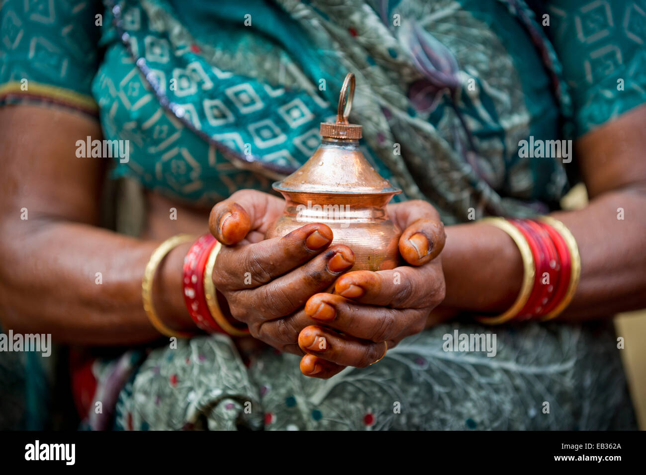 Hände von einer indischen Frau hält ein Gefäß mit Weihwasser, Rameswaram, Pamban Insel, Tamil Nadu, Indien Stockfoto