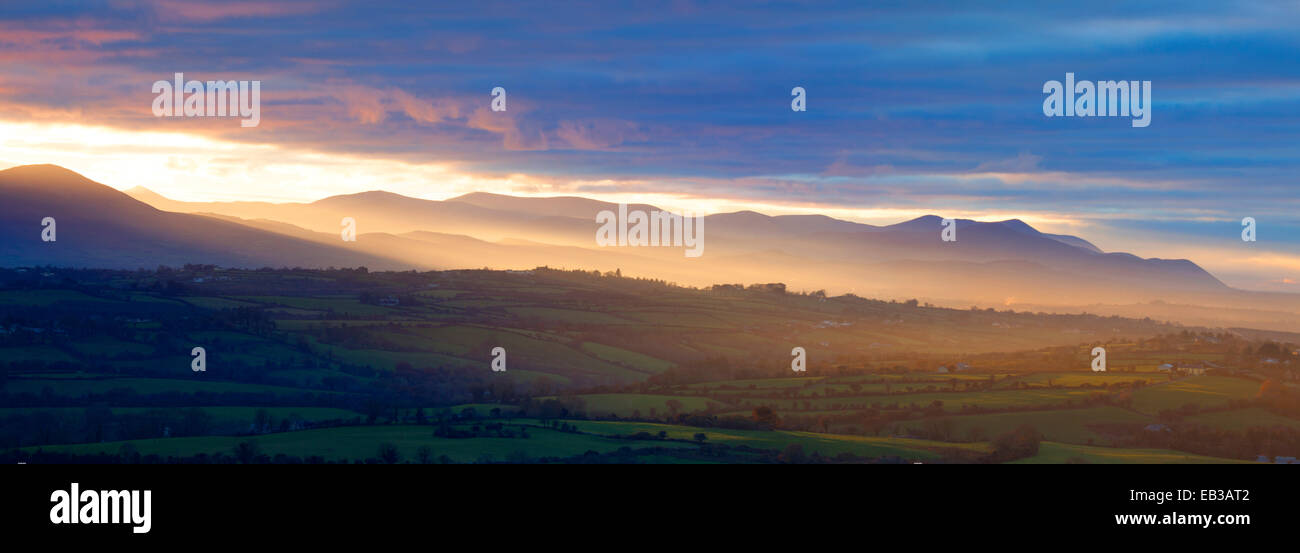 Blick auf den Sonnenuntergang in Richtung der MacGillycuddys Reeks vom in der Nähe von Killarney, Iveragh-Halbinsel, County Kerry, Irland. Stockfoto