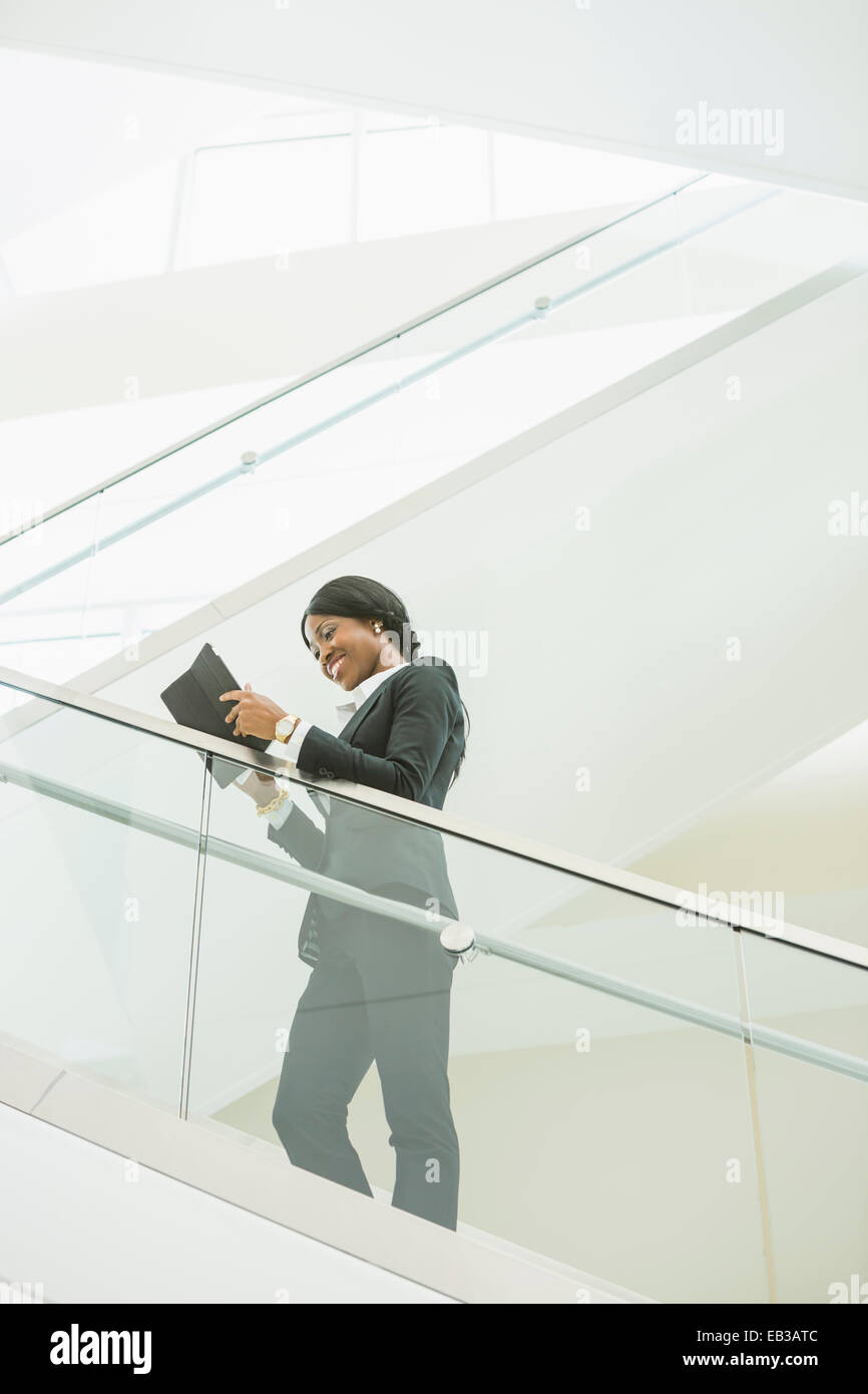 Schwarzen Geschäftsfrau mit digital-Tablette auf Büro-Treppe Stockfoto