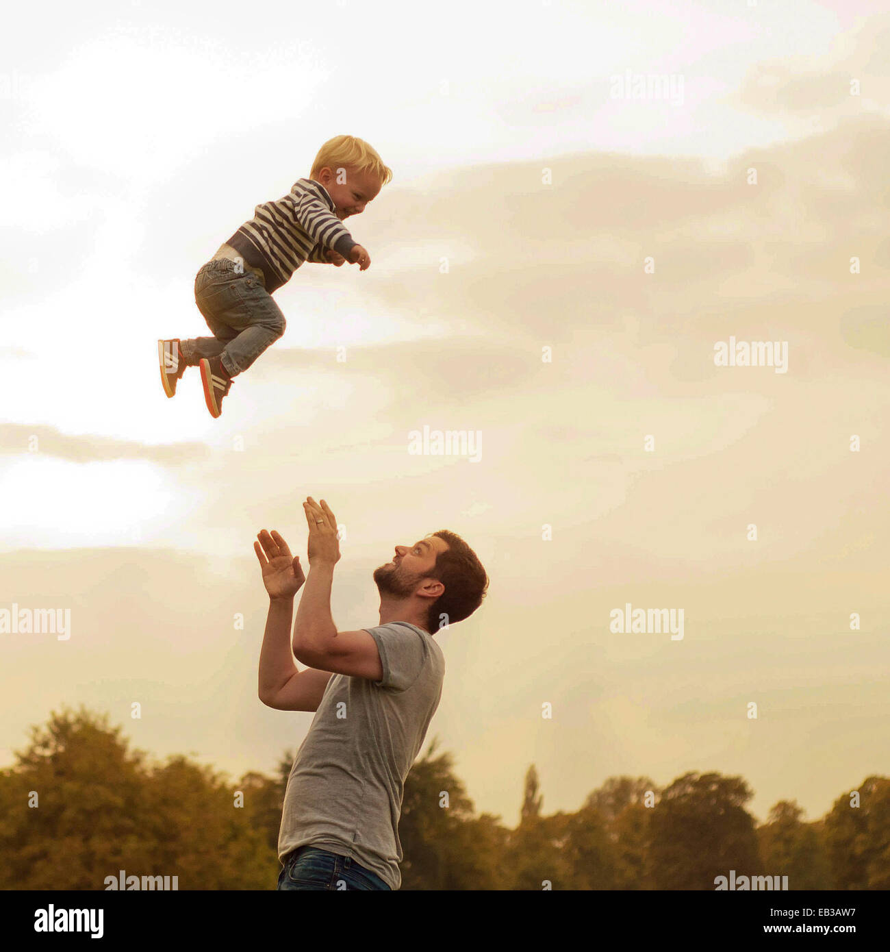 Vater warf Sohn in Luft Stockfoto