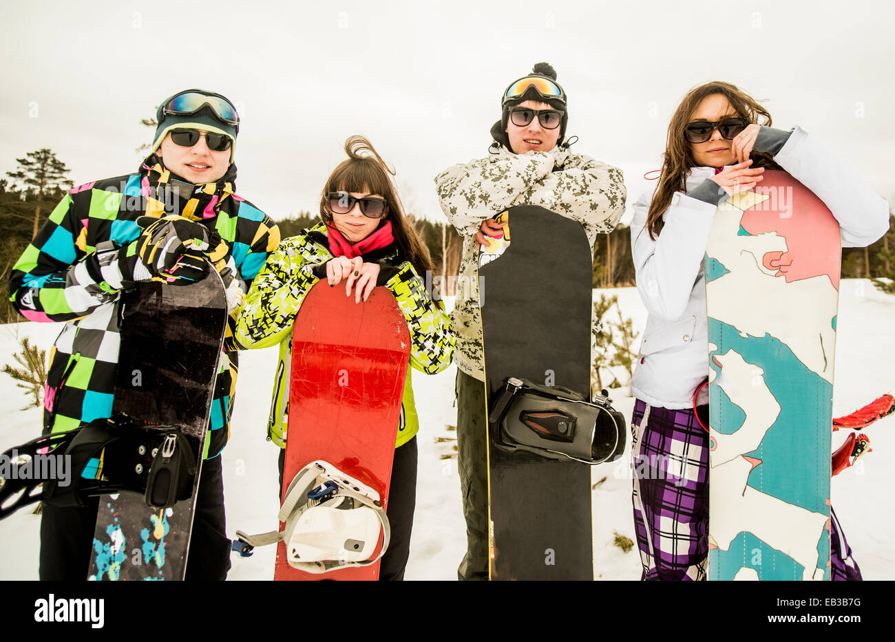 Kaukasischen Paare halten Snowboards im Schnee Stockfoto