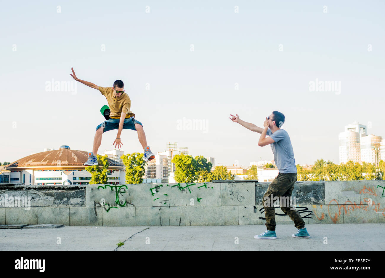 Kaukasische Männer springen in Stadt Stockfoto