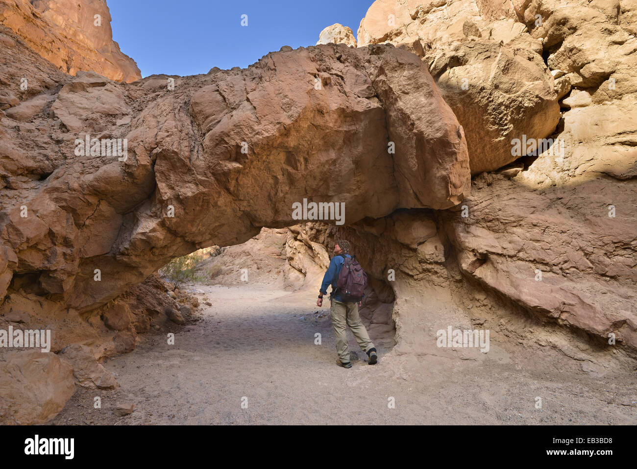 USA, California, Anza-Borrego Desert State Park, Wanderer zu Fuß unter einer natürlichen Brücke Stockfoto
