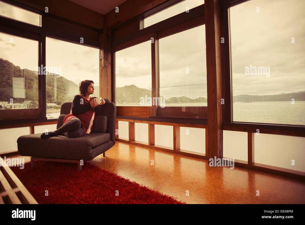 Gemischte Rassen Frau suchen Fenster modernes Haus Stockfoto