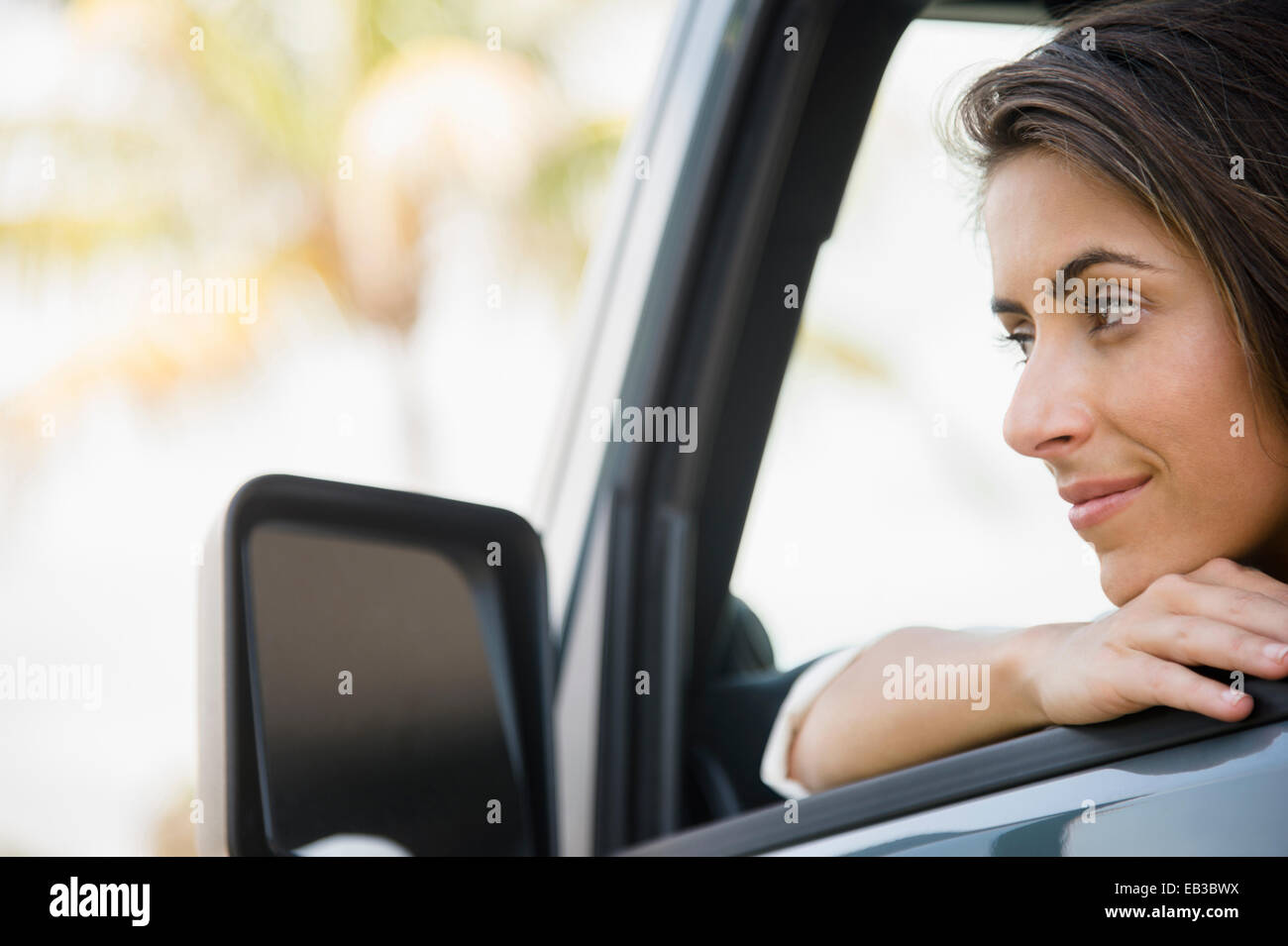 Kaukasische Frau stützte sich auf Autofenster Stockfoto
