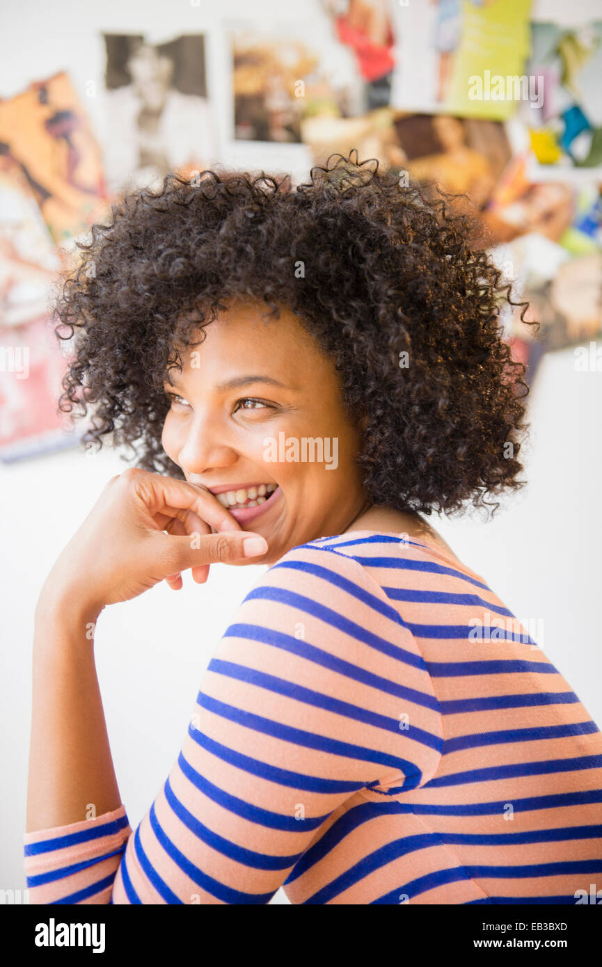 Lächelnde Frau ruht Kinn in die hand Stockfoto